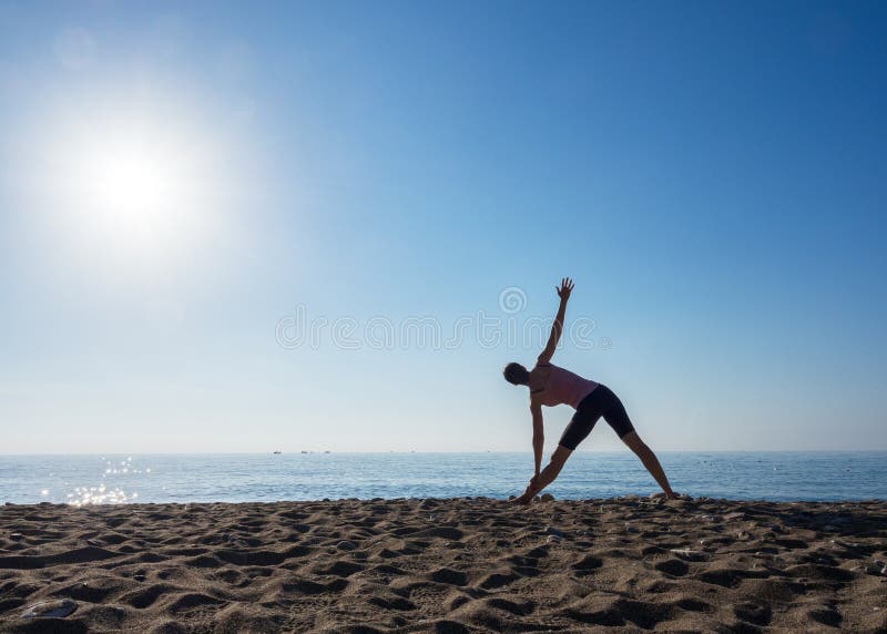 Ensam kvinna som gör yoga på stranden vid havet på en solig dag, selektiv fokus royaltyfria foton Ensam kvinna som gör yoga på stranden vid havet på en solig dag, selektiv fokus royaltyfria foton