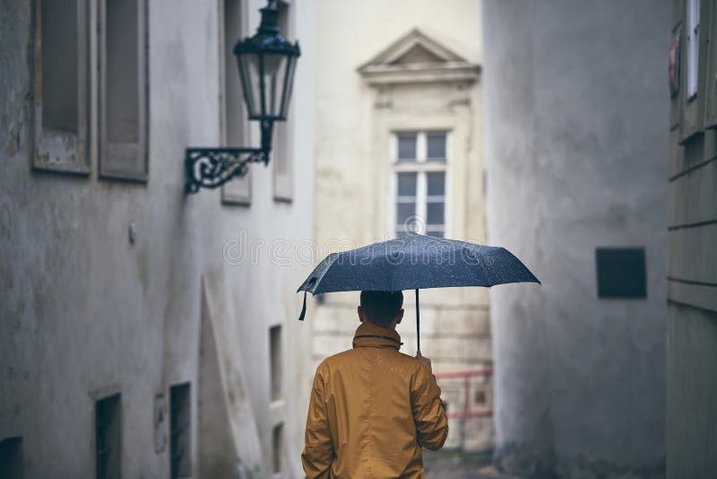 Ensam man med paraplyet i regn royaltyfri fotografi Ensam man med paraplyet i regn royaltyfri fotografi