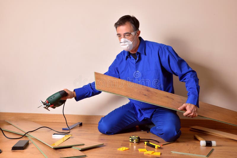 Ensamblador de parquet profesional con máquina de corte en mano ensamblando parquet imagen de archivo libre de regalías