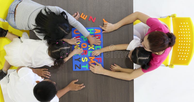 Enseignant asiatique jouer à l'alphabet jouet avec les élèves. banque de vidéos