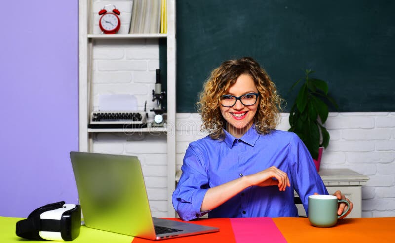 Enseignante en verre avec tasse de thé ou de café sur le lieu de travail. Apprentissage et éducation. Jeune souriant images libres de droits
