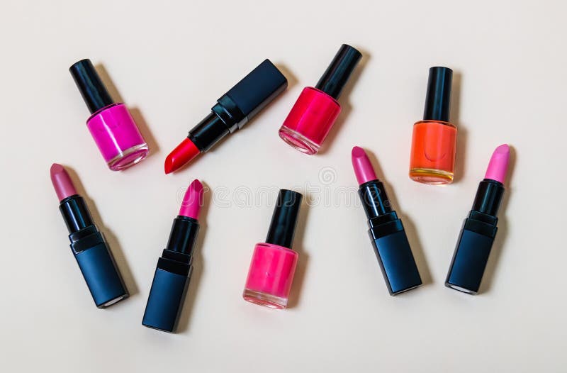 Ensemble de rouges à lèvres et de vernis à ongles sur le fond beige image stock Ensemble de rouges à lèvres et de vernis à ongles sur le fond beige image stock