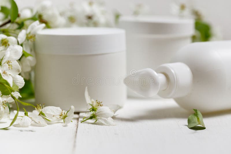 Ensemble de ‹d'†de ‹de packaging†de ‹de care†de ‹de Skin†avec le fond de ‹de white†de ‹d'on†de fleurs de ressort bout image libre de droits Ensemble de ‹d'†de ‹de packaging†de ‹de care†de ‹de Skin†avec le fond de ‹de white†de ‹d'on†de fleurs de ressort bout image libre de droits