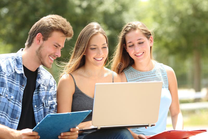 Ensino eletrónico de três estudantes junto em um terreno imagens de stock Ensino eletrónico de três estudantes junto em um terreno imagens de stock