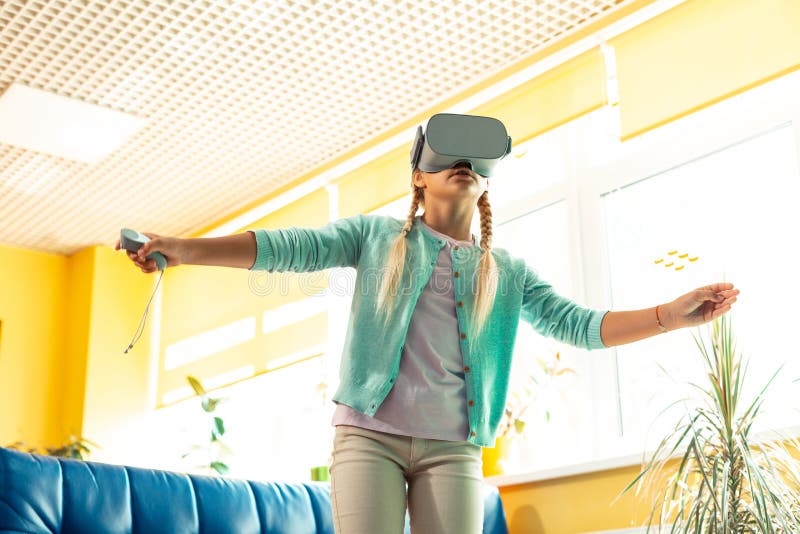 Enthusiastic schoolgirl being wrapped up in virtual reality. royalty free stock images