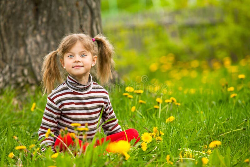 Enthusiastically surprised lovely little girl sitting in grass