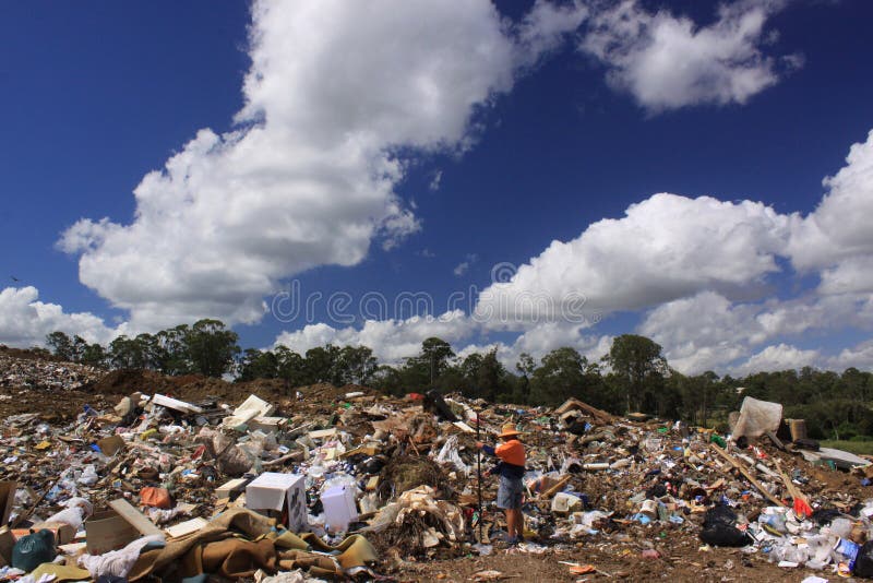 A big collection of household waste and garbage waiting to go to a landfill. A surveyor is doing an estimation of the household waste. A big collection of household waste and garbage waiting to go to a landfill. A surveyor is doing an estimation of the household waste.