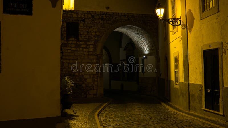 Entrada arqueada antiga em paredes velhas da cidade de Faro, Portugal fotos de stock