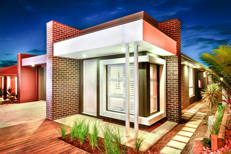 Entrance and facade of a modern mansion with brick walls and col