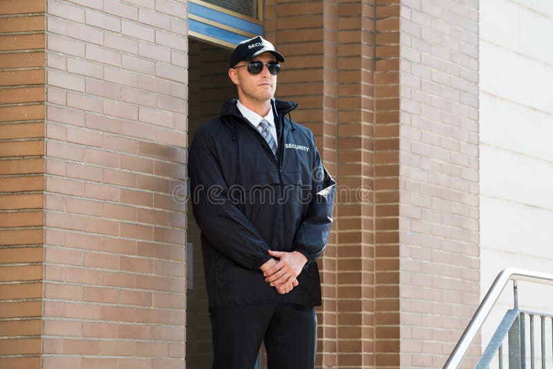 Entrata maschio di Standing At The della guardia giurata fotografia stock libera da diritti Entrata maschio di Standing At The della guardia giurata fotografia stock libera da diritti