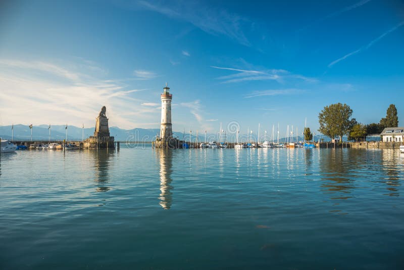 Entrata portuale di Lindau, Lago di Costanza - Germ - Bodensee - con il nuovo faro e il leone bavarese La fotografia stock Entrata portuale di Lindau, Lago di Costanza - Germ - Bodensee - con il nuovo faro e il leone bavarese La fotografia stock