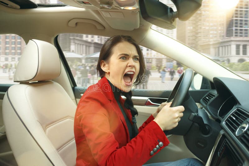 Entraînement autour de la ville Jeune femme attirante conduisant une voiture images stock Entraînement autour de la ville Jeune femme attirante conduisant une voiture images stock