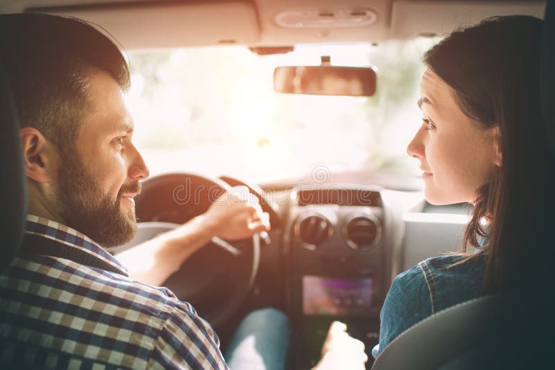 Entraînement soigneux Beaux jeunes couples se reposant sur les sièges de passager plan et souriant tandis qu'homme bel conduisant photos libres de droits Entraînement soigneux Beaux jeunes couples se reposant sur les sièges de passager plan et souriant tandis qu'homme bel conduisant photos libres de droits