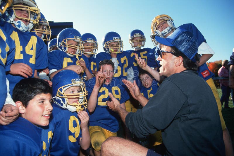 Entraîneur avec l'équipe de football de la jeunesse photographie stock Entraîneur avec l'équipe de football de la jeunesse photographie stock