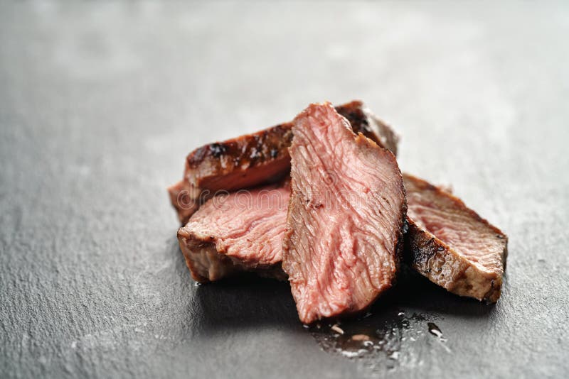 Entrecote beef steak sliced on slate board, shallow focus. Entrecote beef steak sliced on slate board, shallow focus