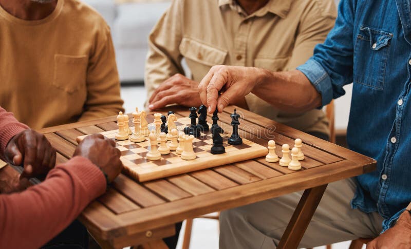 Amigos de xadrez e jogos de tabuleiro na mesa de madeira pensando em  movimento estratégico ou tático em casa grupo sênior de homens jogando e  segurando ou movendo a peça branca para