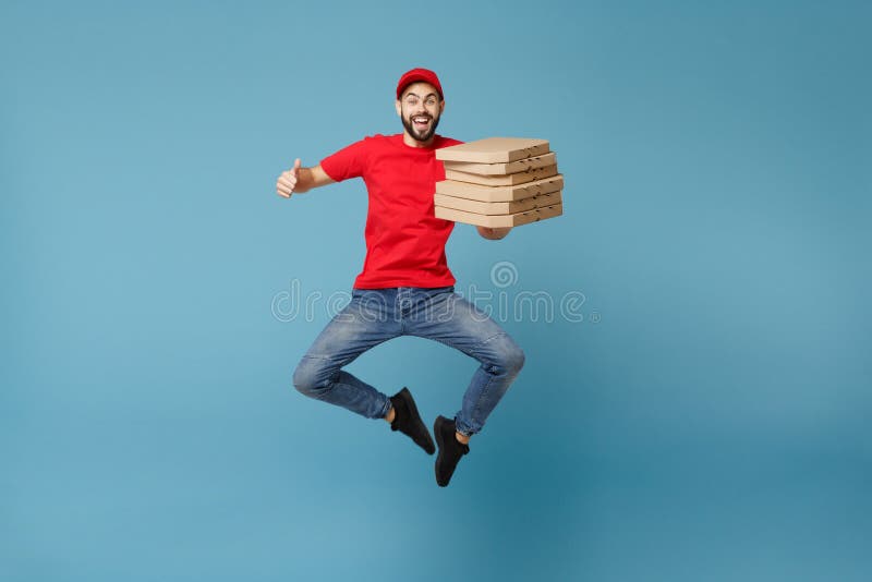 Delivery man in red workwear giving food order pizza boxes isolated on blue background, studio portrait. Professional male employee in cap t-shirt print courier. Service concept. Mock up copy space. Delivery man in red workwear giving food order pizza boxes isolated on blue background, studio portrait. Professional male employee in cap t-shirt print courier. Service concept. Mock up copy space