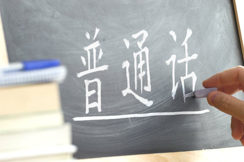 Hand writing on a blackboard in a Chinese class. Some books and school materials. Hand writing on a blackboard in a Chinese class. Some books and school materials.