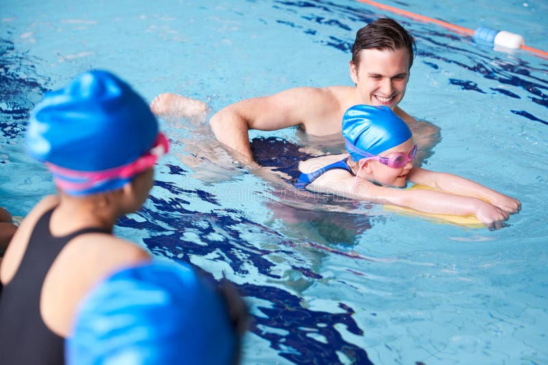 Entrenador Masculino En El Agua, Grupo De Niños En La Piscina Cubierta fotos de archivo