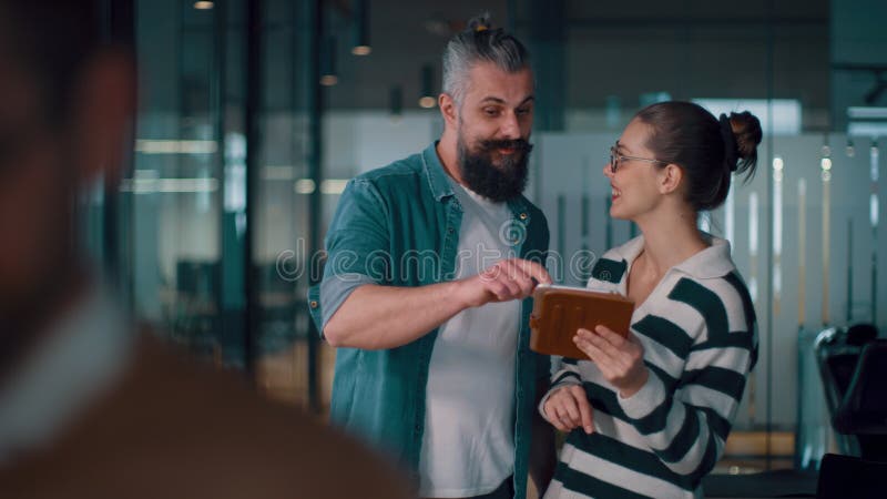 Entrenador o conferenciante masculino que comparte ideas de negocios y colabora con un equipo diverso en una oficina moderna que p metrajes