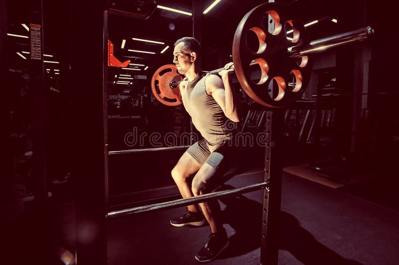 Entrenamiento cruzado Parte del hombre joven en barbell de elevación de la ropa de deportes Imagen entonada fotografía de archivo Entrenamiento cruzado Parte del hombre joven en barbell de elevación de la ropa de deportes Imagen entonada fotografía de archivo