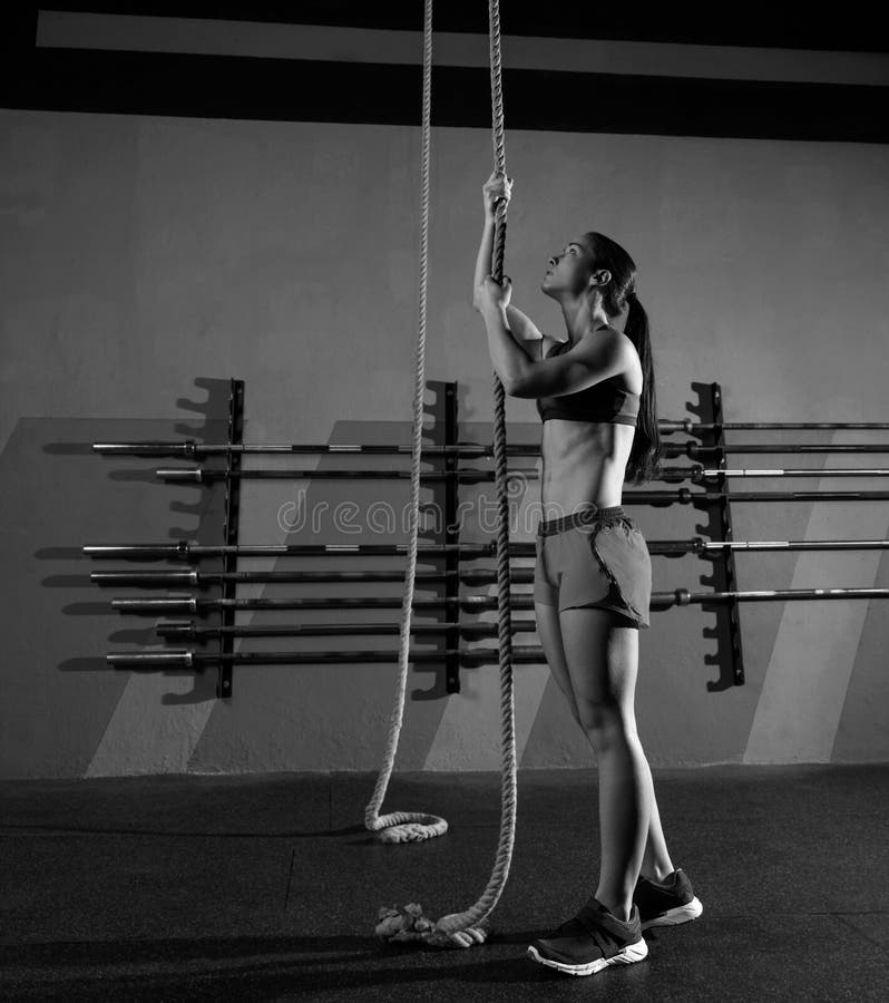 Entrenamiento de la mujer del ejercicio de la subida de la cuerda en el gimnasio foto de archivo libre de regalías Entrenamiento de la mujer del ejercicio de la subida de la cuerda en el gimnasio foto de archivo libre de regalías