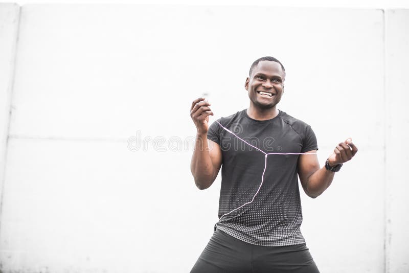 Entrenamiento y hacer masculinos jovenes sonrientes del atleta del basculador aire libre del entrenamiento en ciudad un hombre ne imagenes de archivo Entrenamiento y hacer masculinos jovenes sonrientes del atleta del basculador aire libre del entrenamiento en ciudad un hombre ne imagenes de archivo