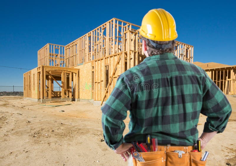 Entrepreneur avec le casque antichoc à la nouvelle maison encadrant au chantier de construction photo stock Entrepreneur avec le casque antichoc à la nouvelle maison encadrant au chantier de construction photo stock