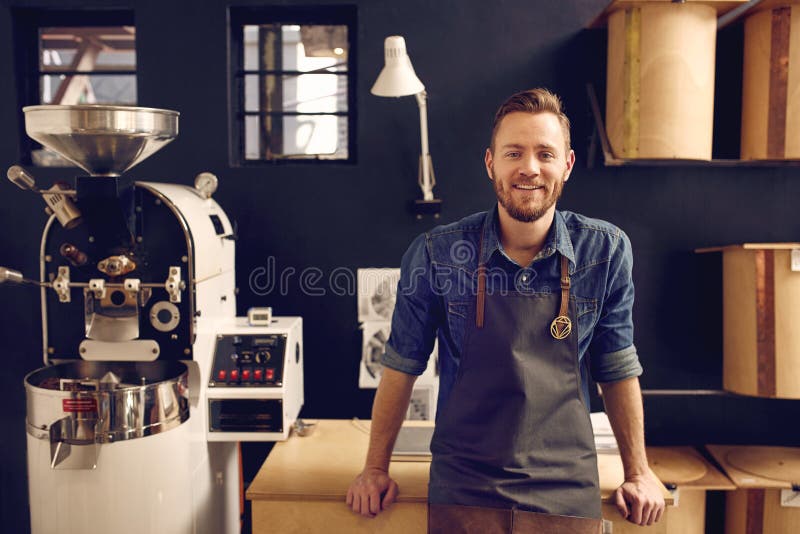 Entrepreneur dans sa station thermale moderne de roastrery et de distribution de café photo stock