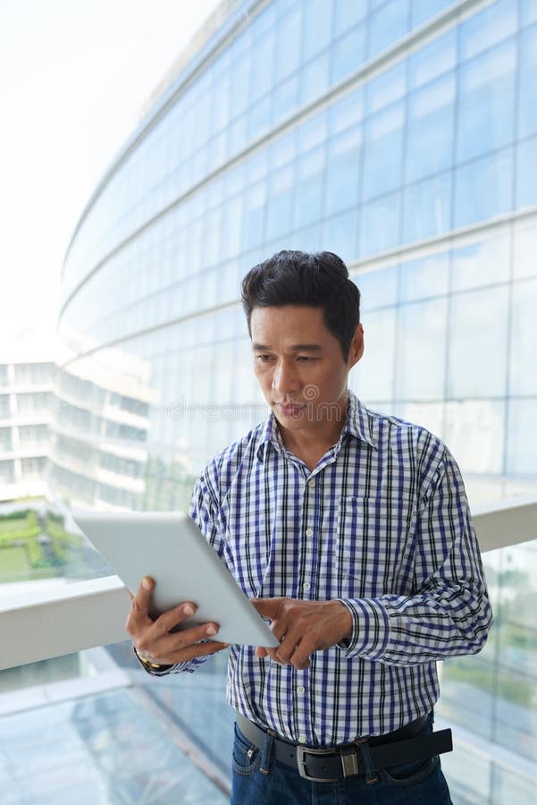 Entrepreneur Reading Article on Tablet Computer stock photo