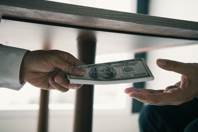 Entrepreneurs are receiving money under the desk that is a bribe of their partners with both of whom are corrupt in the company. Room royalty free stock images Entrepreneurs are receiving money under the desk that is a bribe of their partners with both of whom are corrupt in the company. Room royalty free stock images