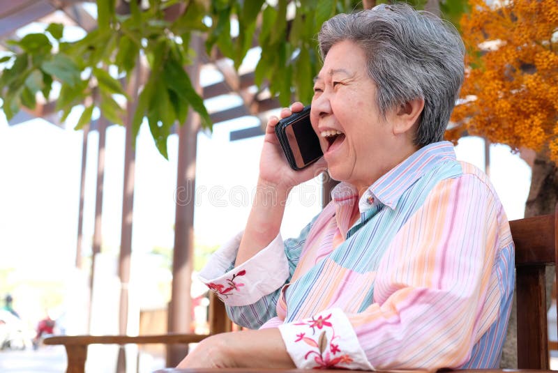entretien de femme plus âgée au téléphone portable dans le jardin la femelle pluse âgé parlent