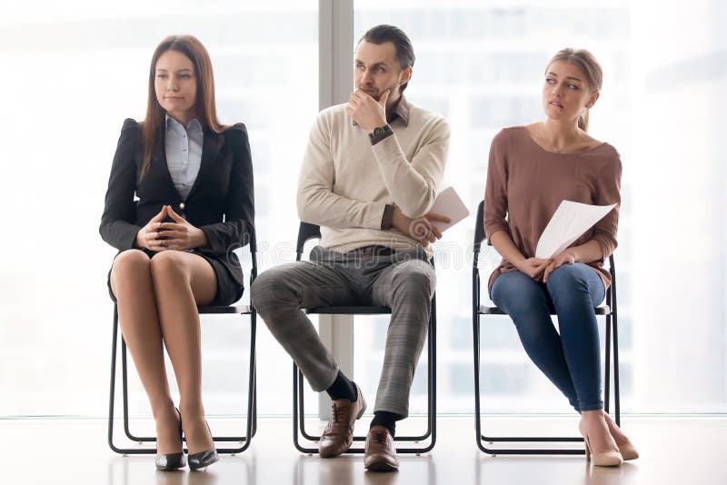 Entrevista de trabalho de espera Sittin preocupado e nervoso dos candidatos imagem de stock Entrevista de trabalho de espera Sittin preocupado e nervoso dos candidatos imagem de stock