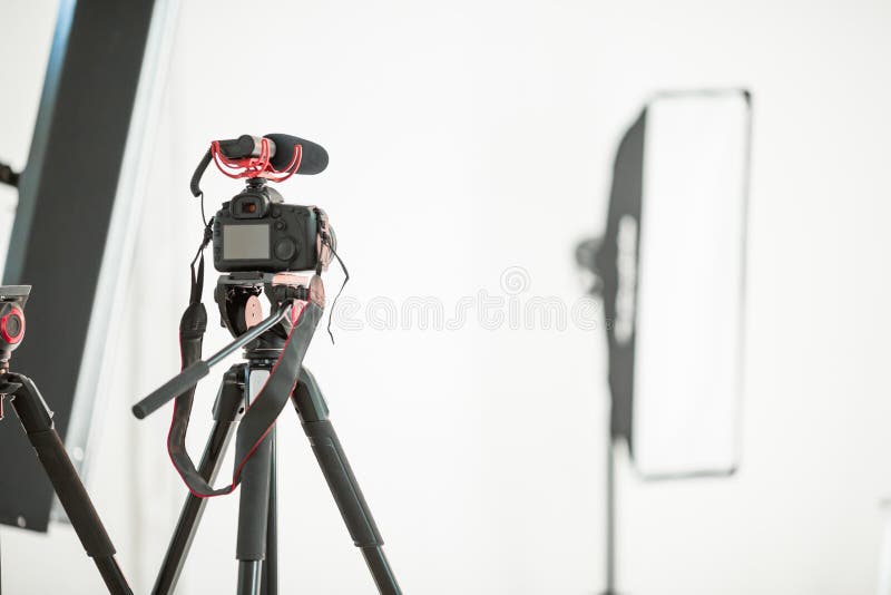 Entrevue de concept, appareil photo numérique sur un trépied avec un microphone dans le studio sur un fond blanc image libre de droits Entrevue de concept, appareil photo numérique sur un trépied avec un microphone dans le studio sur un fond blanc image libre de droits