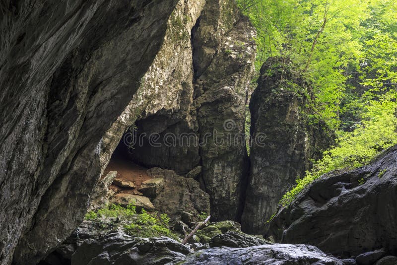 Entrée de caverne et grandes falaises image stock Entrée de caverne et grandes falaises image stock