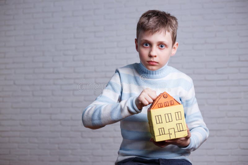 Entsetzter Junge, der zum Pappspielzeughaus klopft Jugendlich und Kinder p stockfotos Entsetzter Junge, der zum Pappspielzeughaus klopft Jugendlich und Kinder p stockfotos