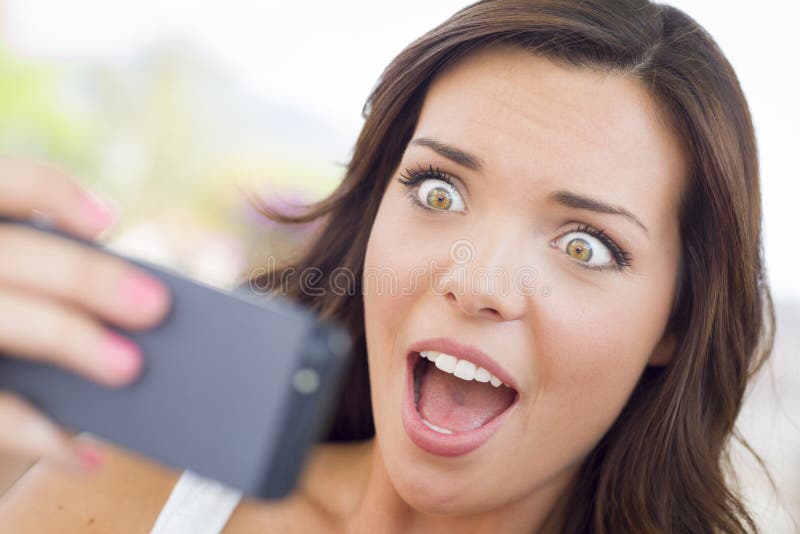 Entsetzter junger erwachsene Frau-Lesehandy Outd lizenzfreie stockfotos Entsetzter junger erwachsene Frau-Lesehandy Outd lizenzfreie stockfotos