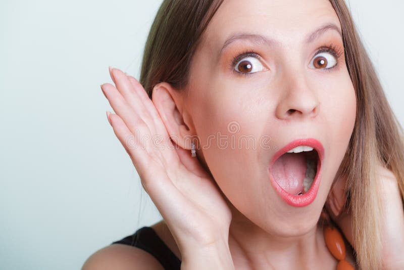 Entsetztes Klatschmädchen, das mit der Hand zum Ohr heimlich zuhört stockbild Entsetztes Klatschmädchen, das mit der Hand zum Ohr heimlich zuhört stockbild