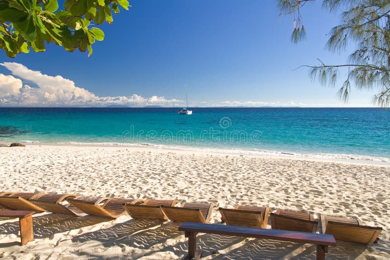 Deck chair, beach and sailboat. Deck chair, beach and sailboat