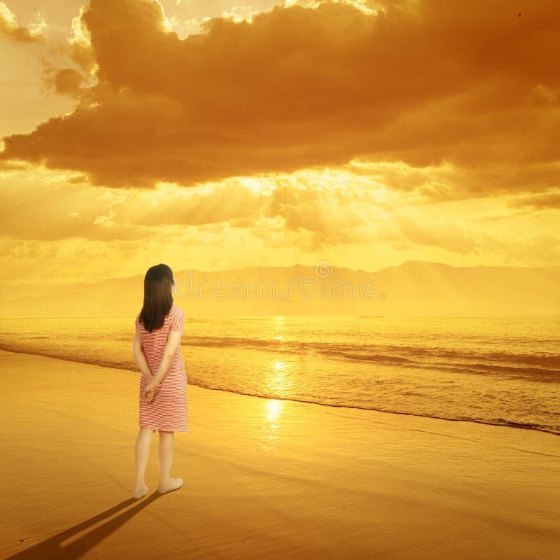 Entspannen Sie sich die Frau, die auf Strand-Sonnenuntergang und Berg steht