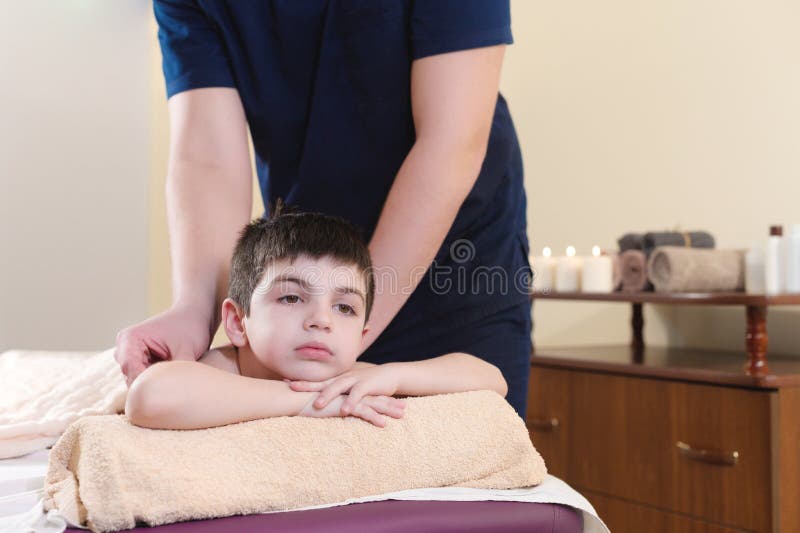 Entspannter kleiner Junge bei Empfang am Chiropraktor Wellnessmassageverfahren lizenzfreies stockbild Entspannter kleiner Junge bei Empfang am Chiropraktor Wellnessmassageverfahren lizenzfreies stockbild