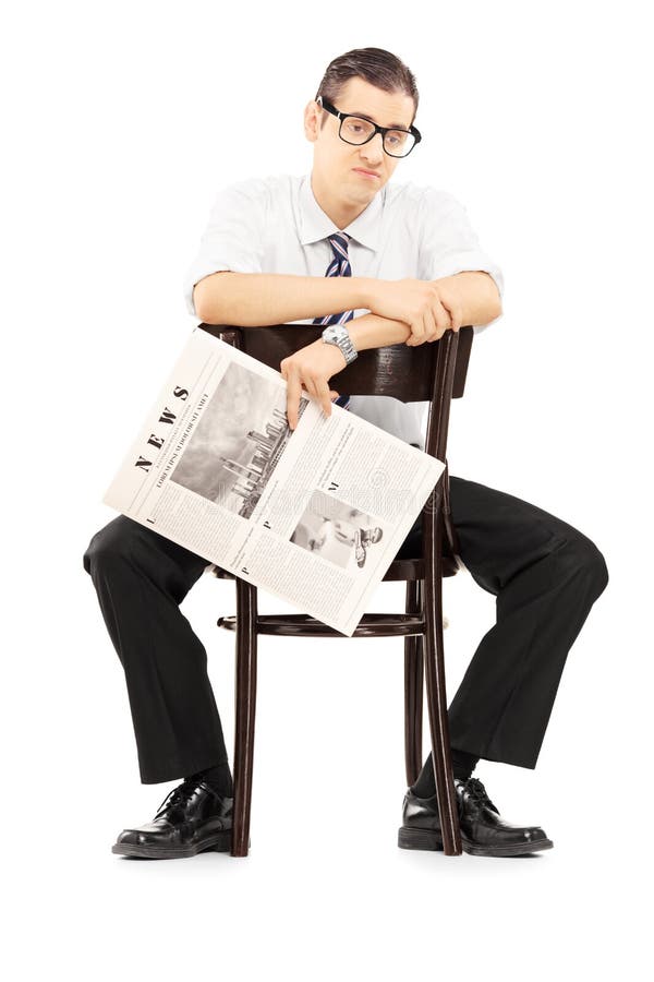 Enttäuschter Wirtschaftler, der auf einem Stuhl mit Zeitung sitzt