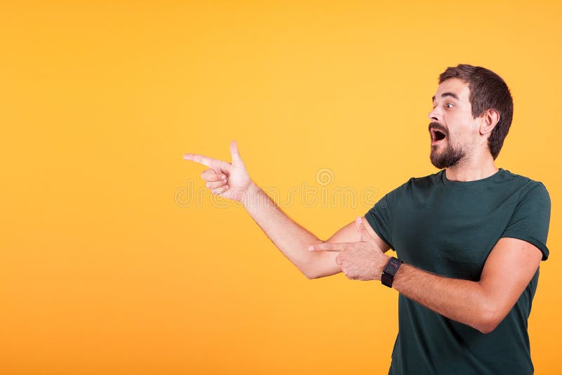 Entusiasmo ed uomo espressivo che indicano al copyspace fotografia stock libera da diritti Entusiasmo ed uomo espressivo che indicano al copyspace fotografia stock libera da diritti