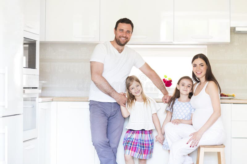 Entzückende junge große Familie, die auf Küche umfasst stockfotos Entzückende junge große Familie, die auf Küche umfasst stockfotos