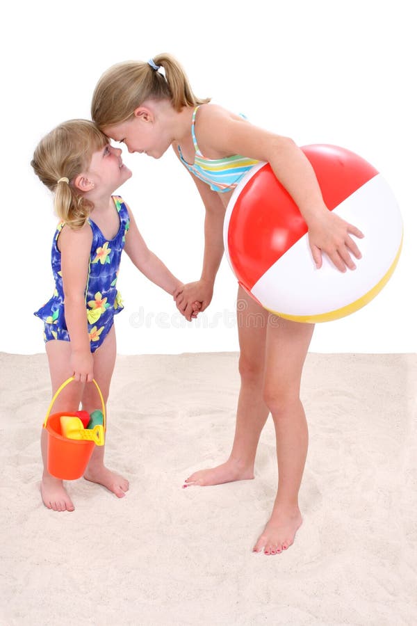 Entzückende Schwestern, die im Sand spielen lizenzfreie stockfotos Entzückende Schwestern, die im Sand spielen lizenzfreie stockfotos