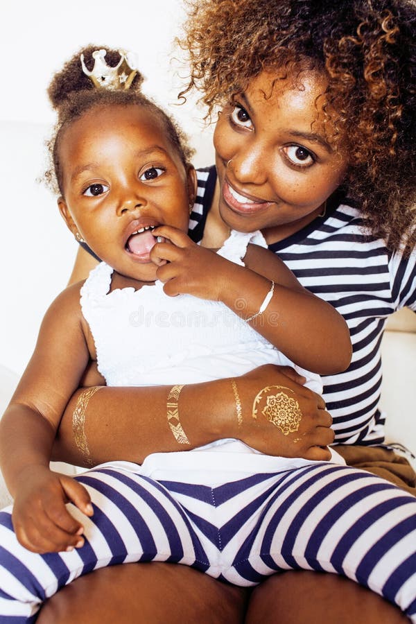 Liebevolle, junge afroamerikanische Mutter mit einer süßen kleinen Tochter, zu Hause beim Spielen und Lachen, Lifestyle-Konzept, g stockbilder