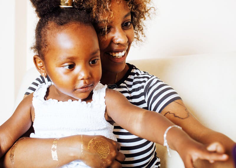Liebevolle, junge afroamerikanische Mutter mit einer süßen kleinen Tochter, zu Hause beim Spielen und Lachen, Lifestyle-Konzept, g stockfoto