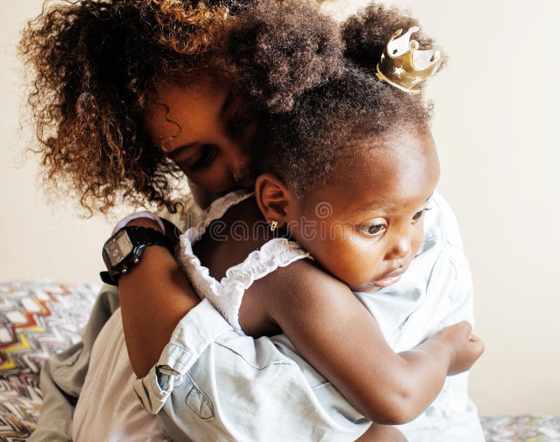 Liebevolle, junge afroamerikanische Mutter mit einer süßen kleinen Tochter, zu Hause beim Spielen und Lachen, Lifestyle-Konzept, g stockfotografie