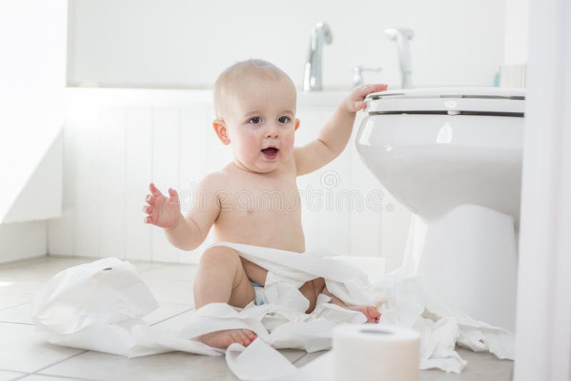 Entzückendes Baby, das mit Toilettenpapier spielt stockbilder Entzückendes Baby, das mit Toilettenpapier spielt stockbilder