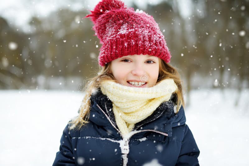 Entzückendes kleines Mädchen, das Spaß im schönen Winterpark hat Nettes Kind, das in einem Schnee spielt stockfotos Entzückendes kleines Mädchen, das Spaß im schönen Winterpark hat Nettes Kind, das in einem Schnee spielt stockfotos